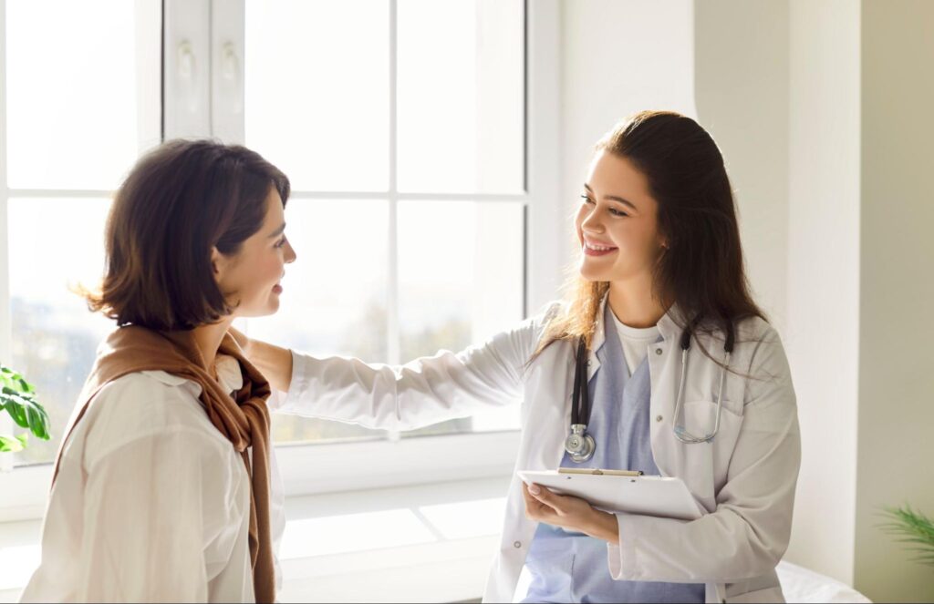 Doctor reassuring patient during women's health exam.
